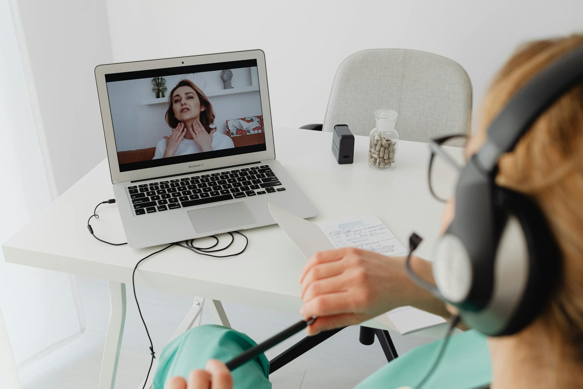 Healthcare professional working on laptop computer with medical documents and stethoscope on desk