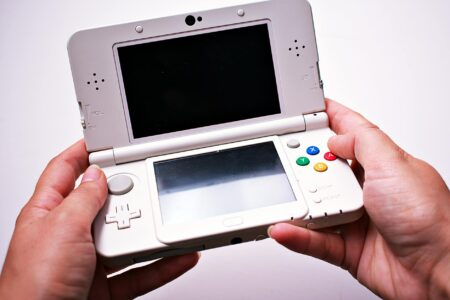 Comparing Steam Deck vs Nintendo Switch OLED for Indie Gaming Portable gaming device on wooden surface showing handheld gaming setup