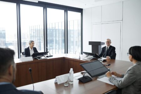 Professional business meeting with lawyers discussing documents around conference table