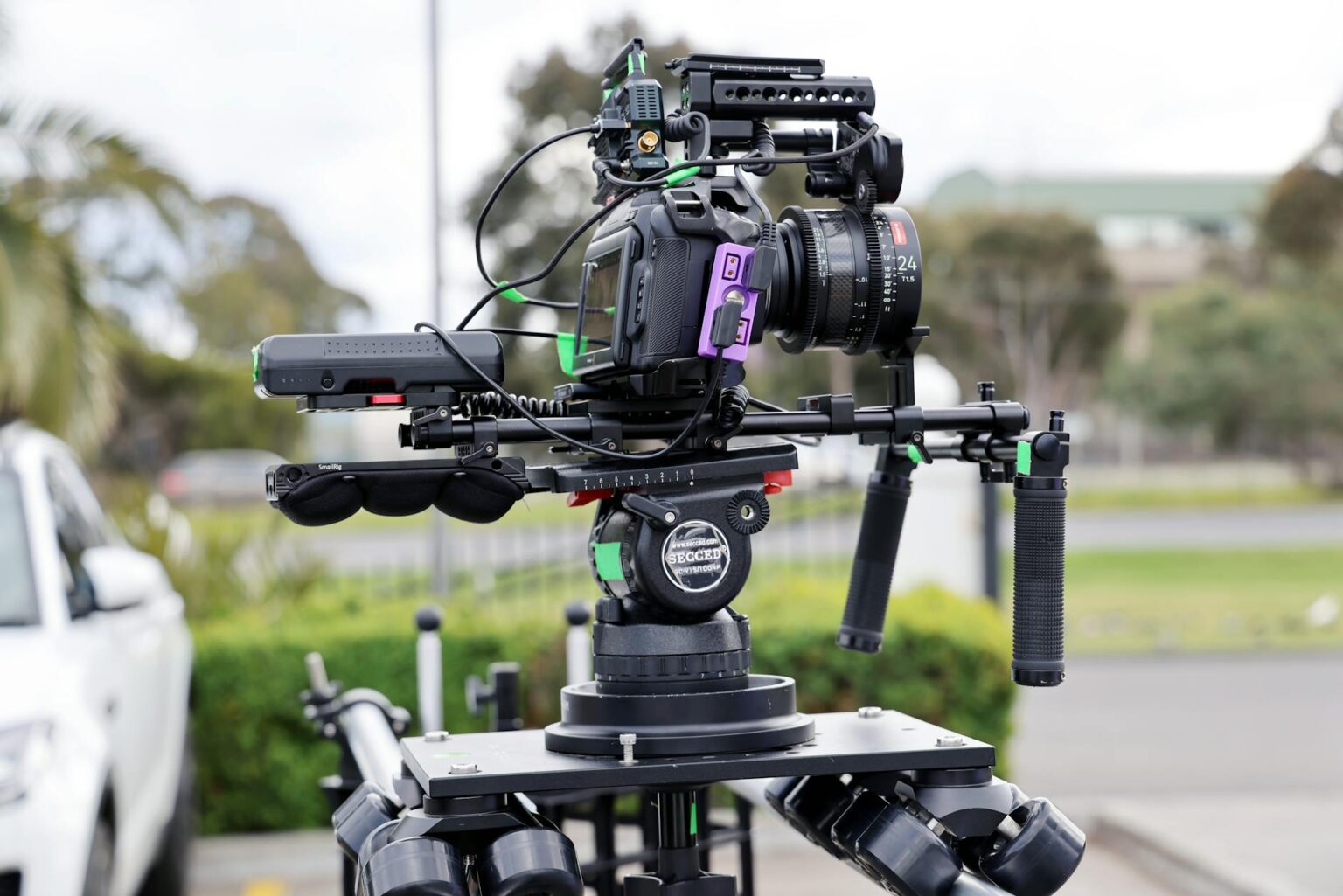 Professional video camera on tripod in filming setup with lighting equipment