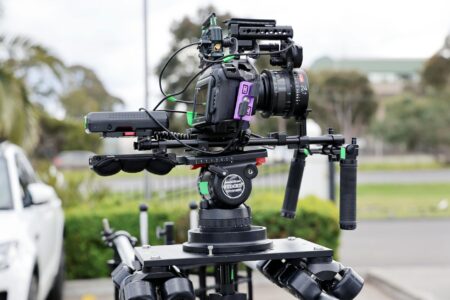 How YouTube’s Creator Revenue Sharing Changes Are Affecting Independent Filmmakers Professional video camera on tripod in filming setup with lighting equipment