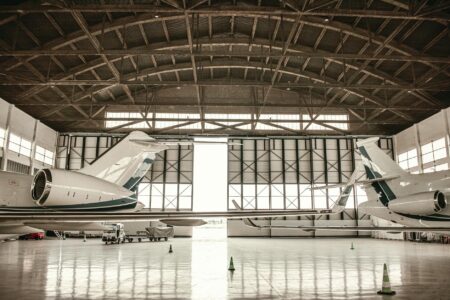 Aircraft maintenance technician working on airplane engine in hangar facility