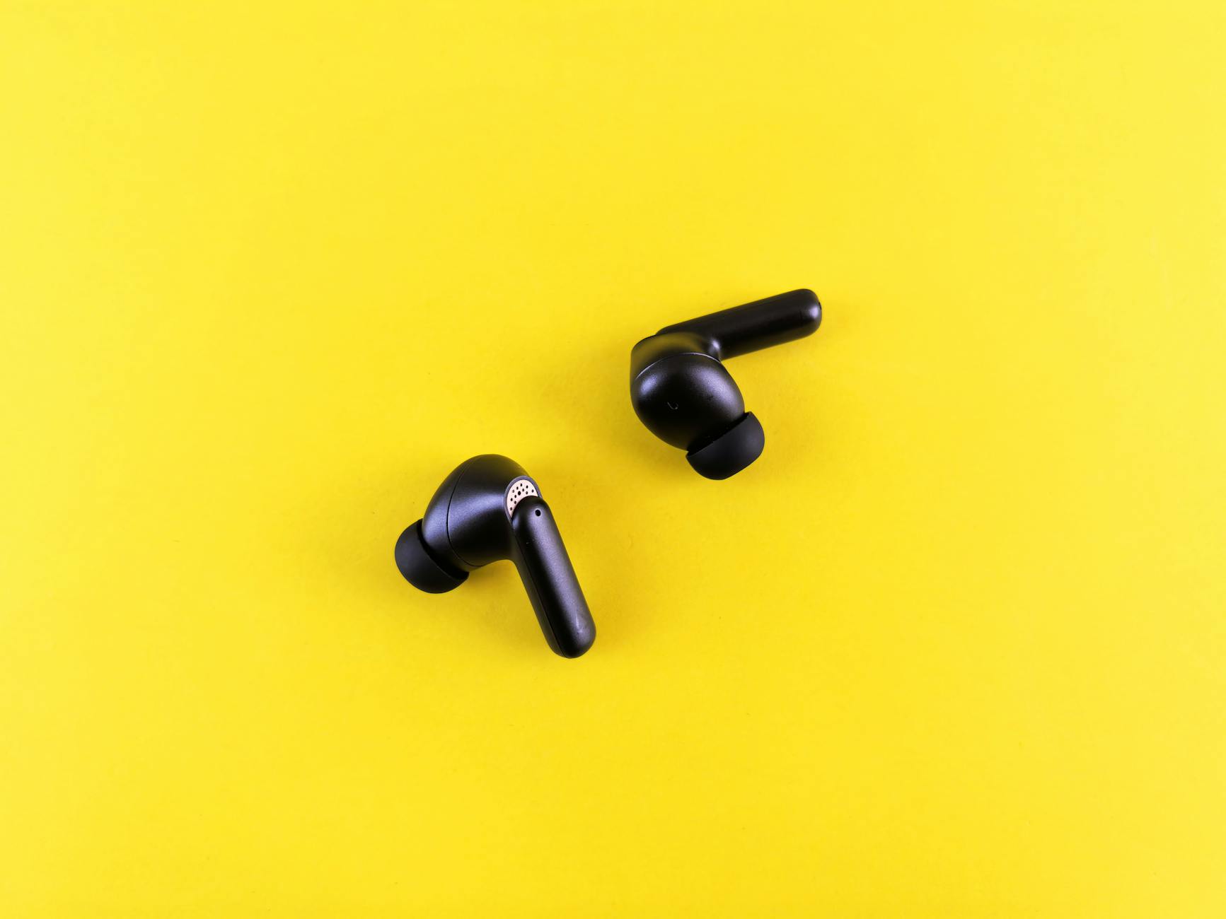 Modern wireless earbuds on a clean white surface showing premium audio technology design