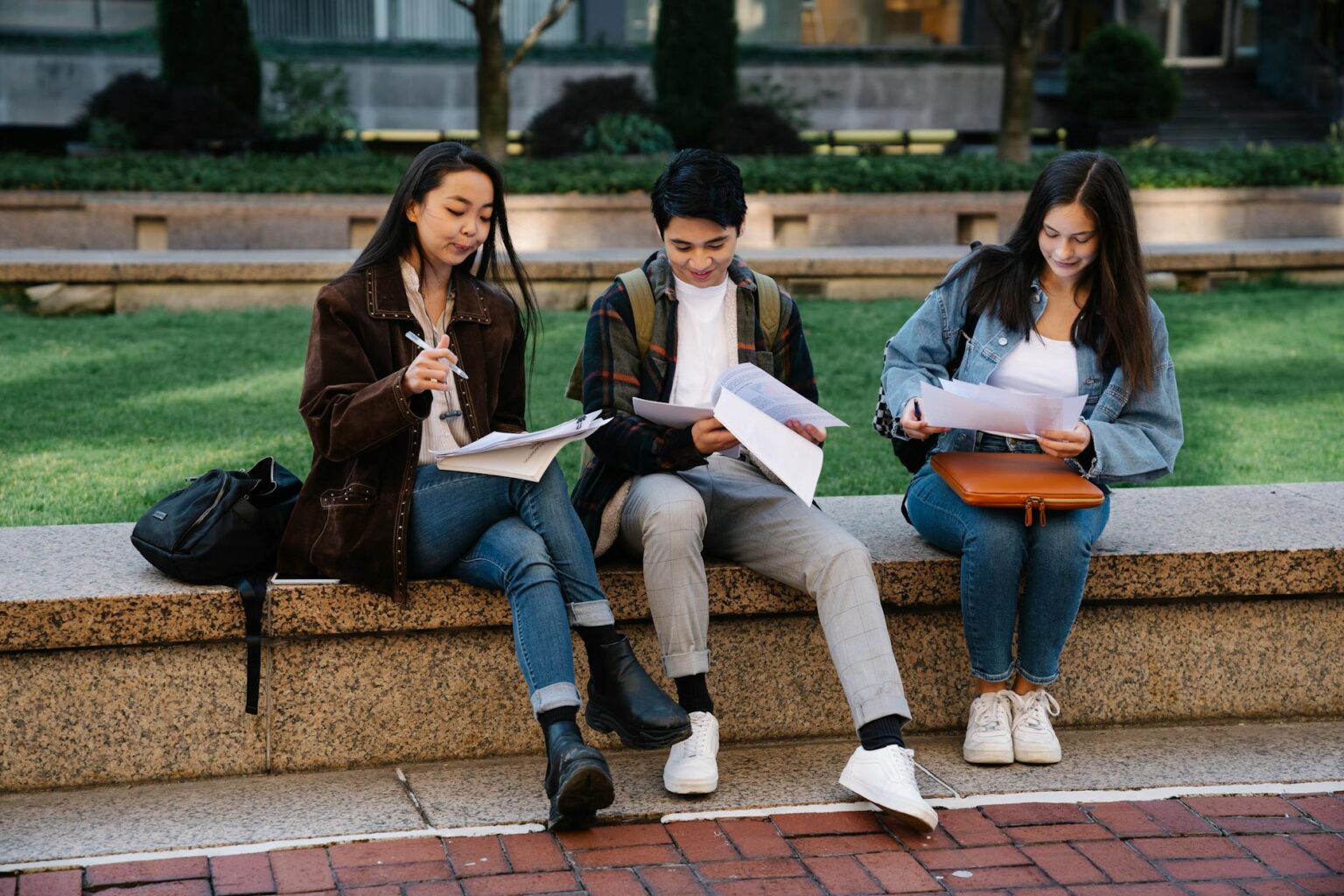 Students walking across a college campus with backpacks and books