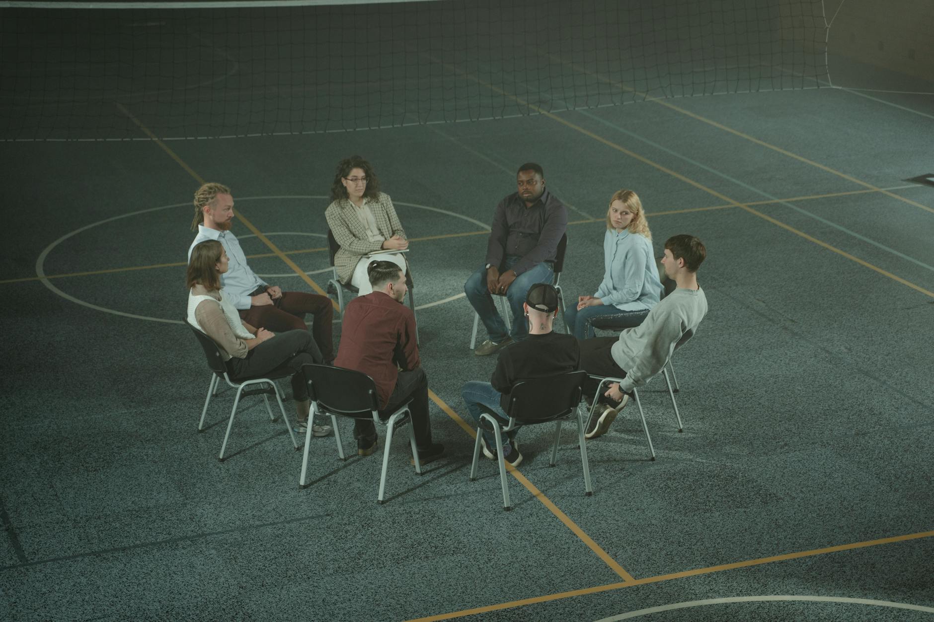 Diverse group of people sitting in circle during support group discussion
