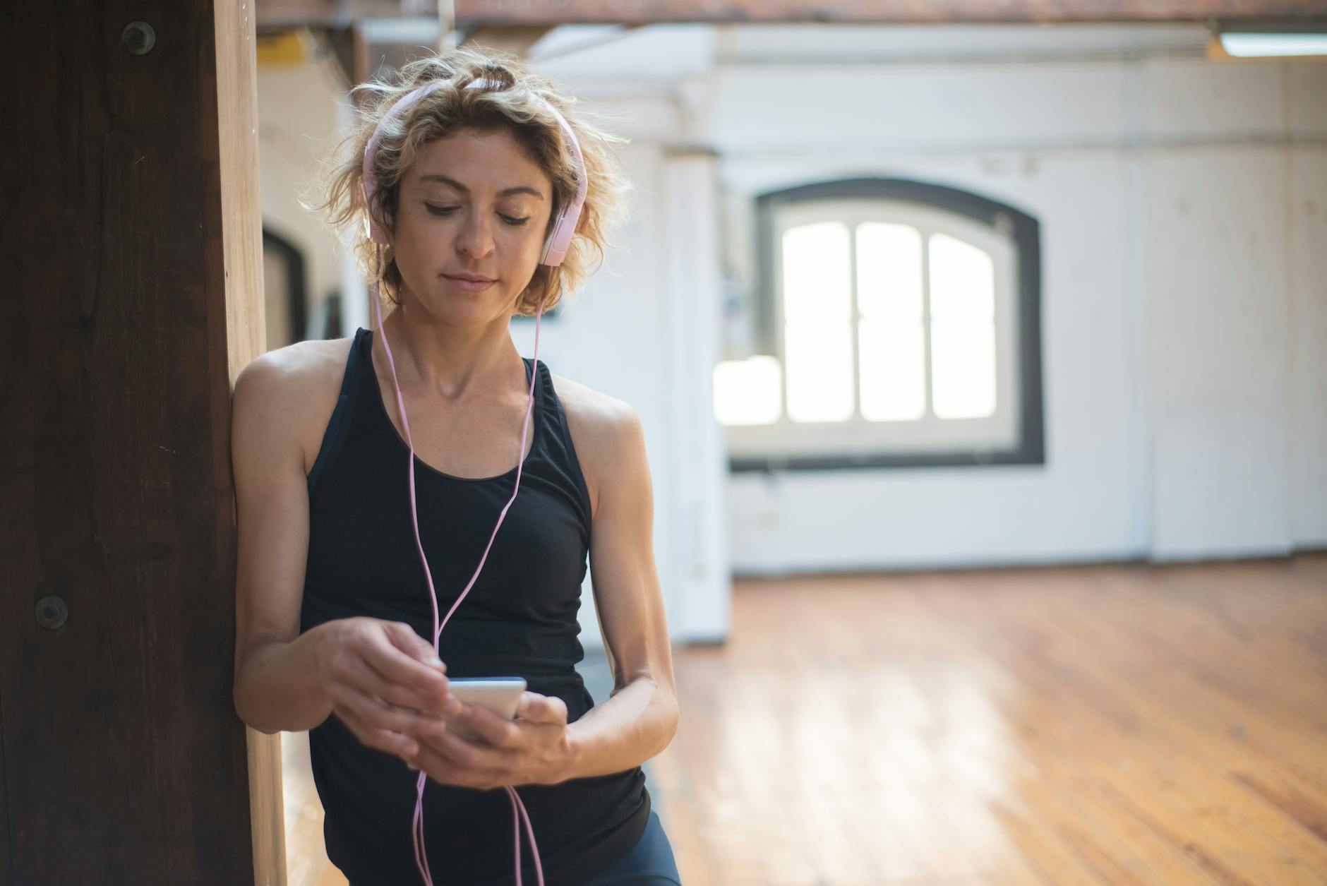 Person listening to audio content on smartphone with headphones
