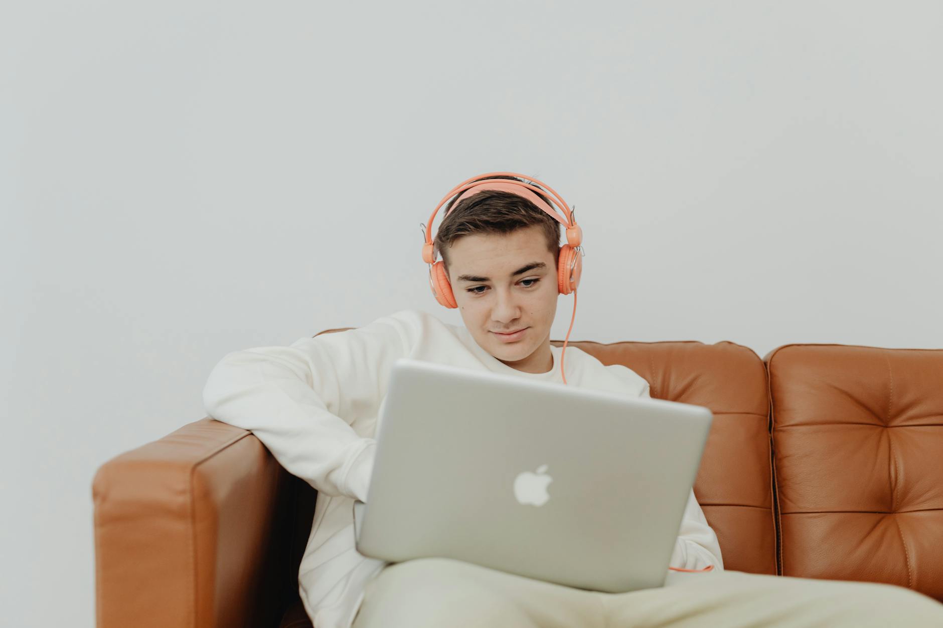 Young woman wearing headphones while studying on laptop, focused on online language learning
