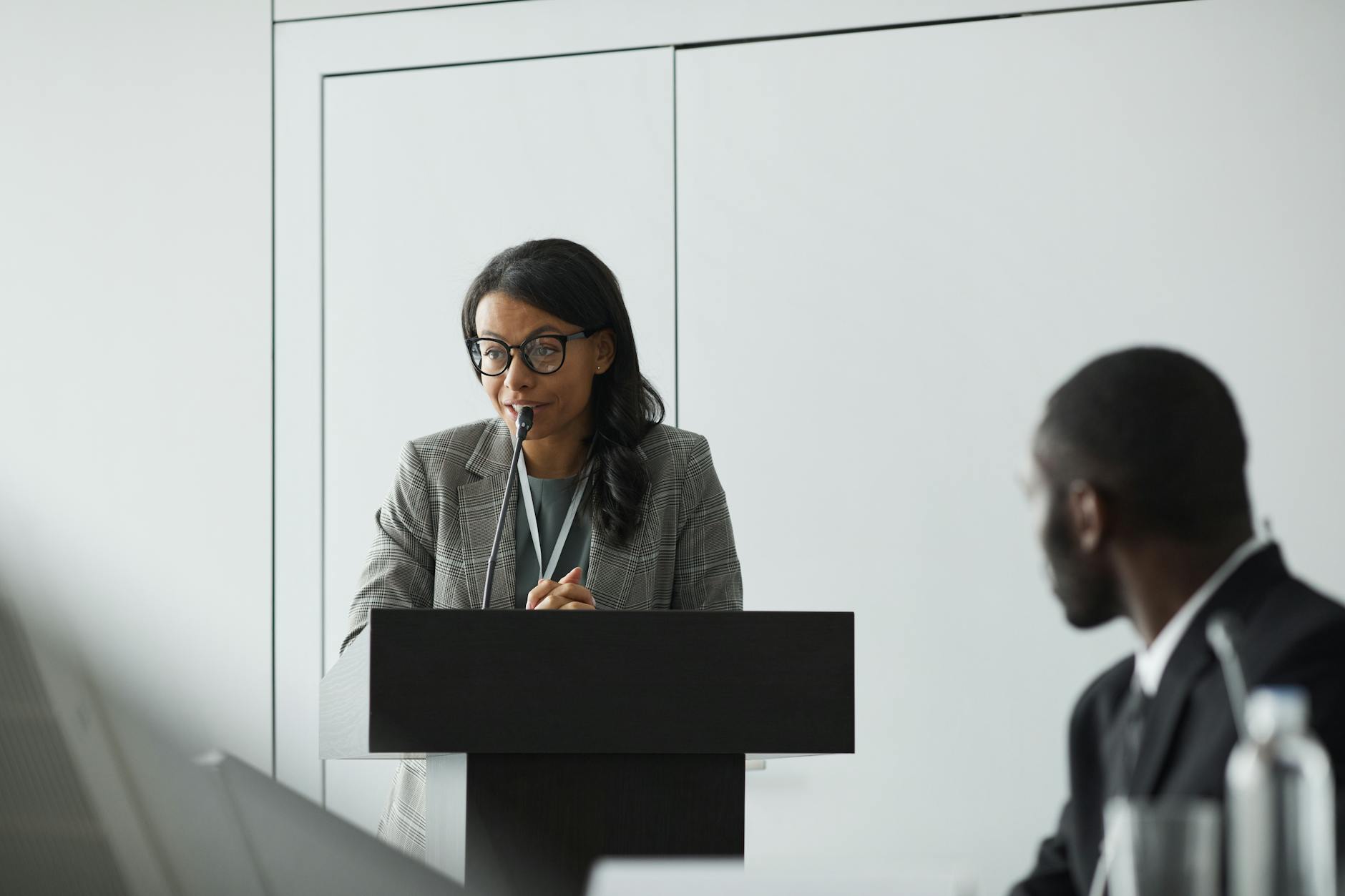 Professional woman giving presentation at podium with confident posture