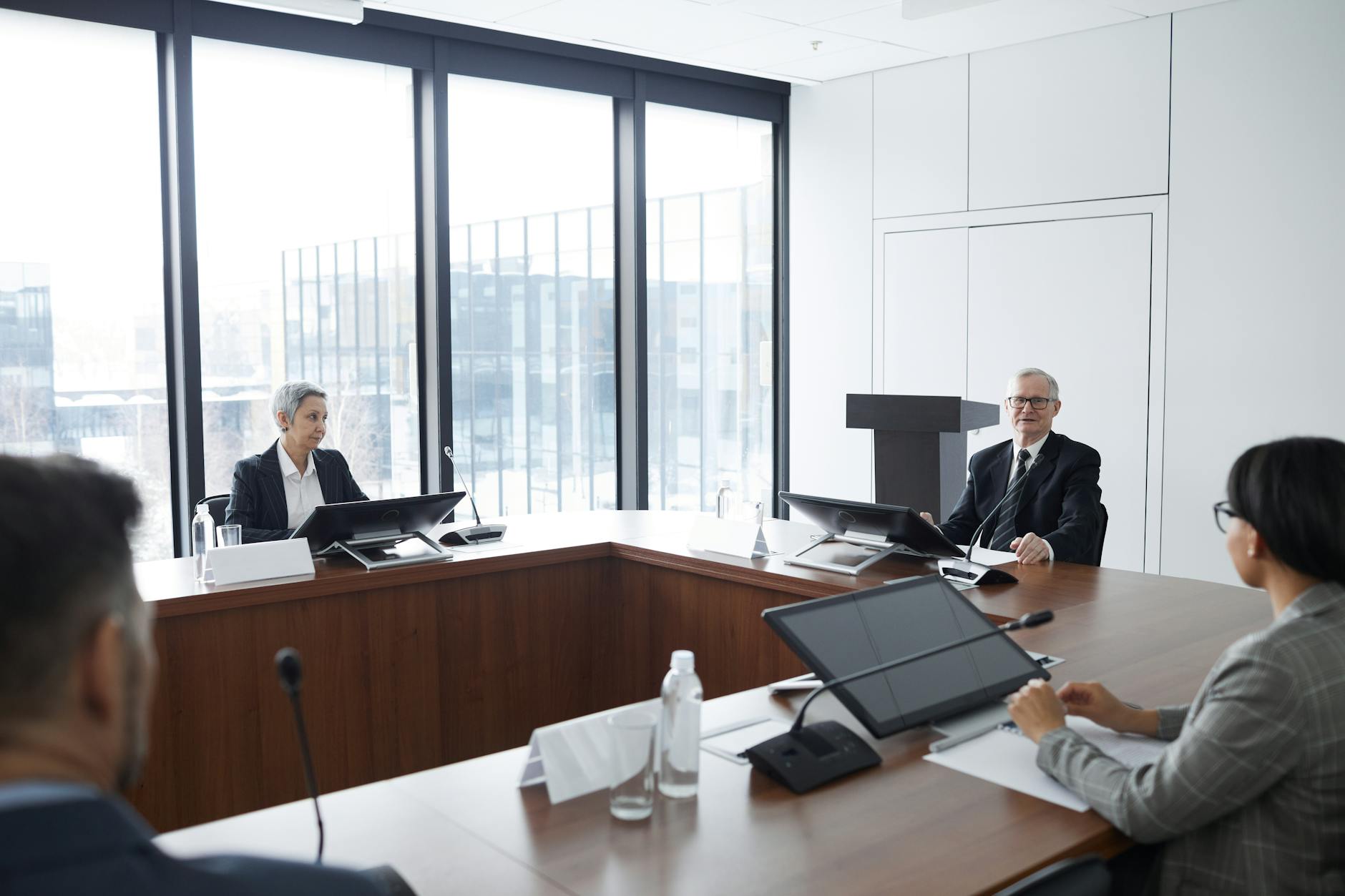 Professional business meeting with people discussing documents around conference table