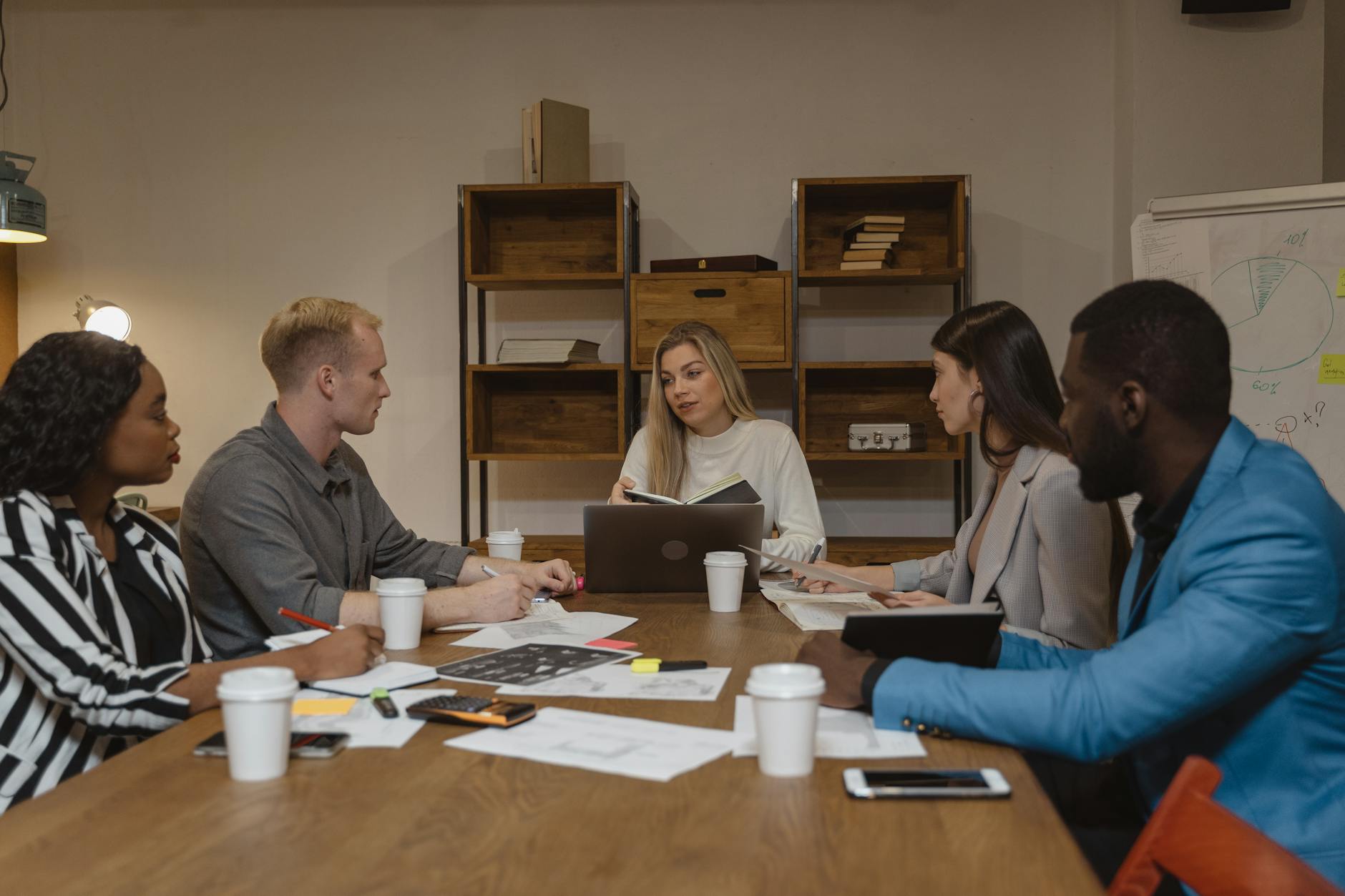 Multi-generational business team having discussion in modern office conference room