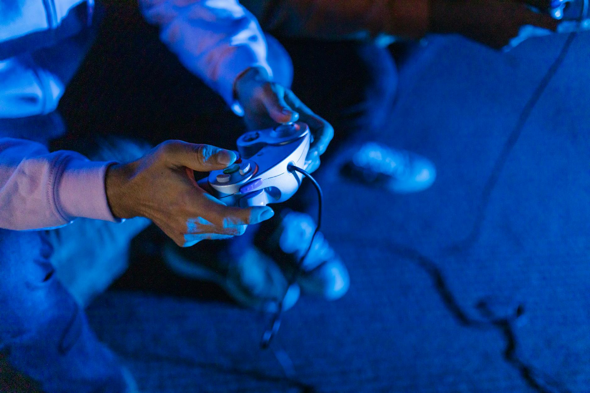 Person's hands holding gaming controller during gameplay session