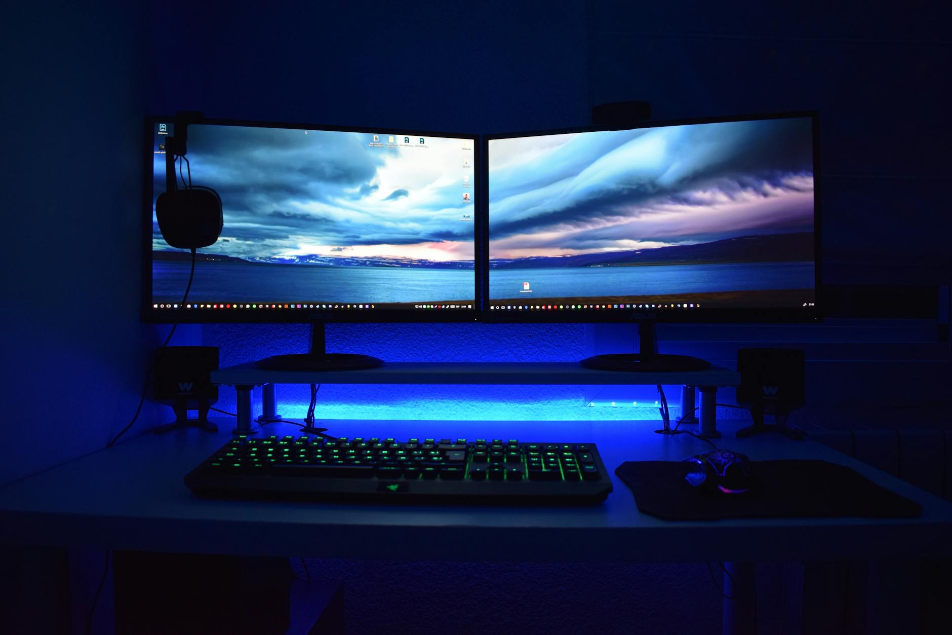 Professional gaming setup with multiple monitors displaying development tools and interfaces