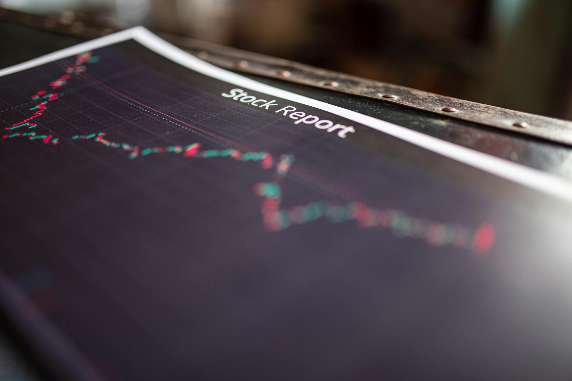 Financial data and charts displayed on multiple screens in trading environment