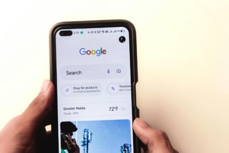Glean’s Workplace Search Tool Is Threatening Microsoft Copilot’s Grip Employee using AI search tool on a laptop in a modern office environment