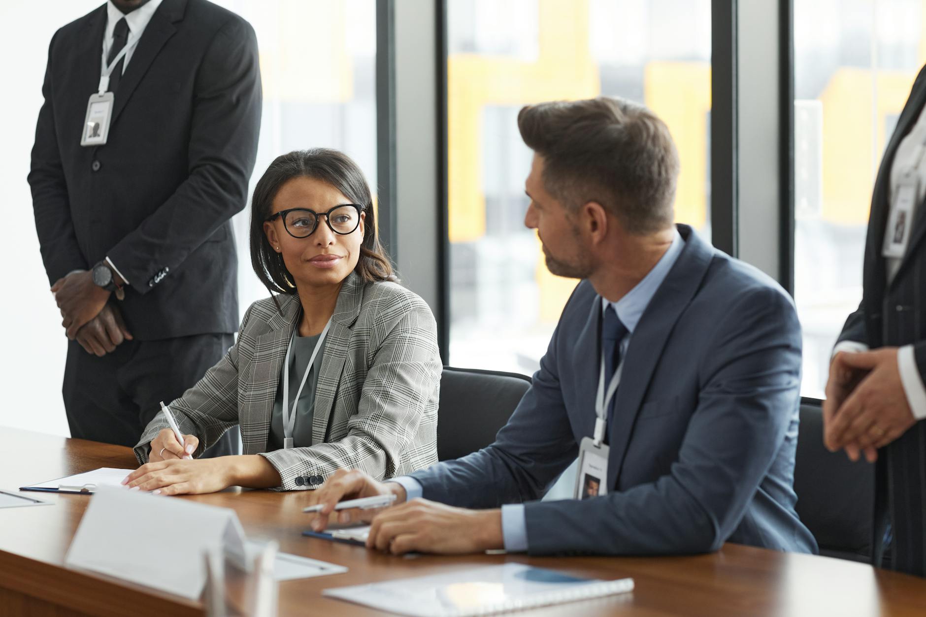 Professional business meeting with executives discussing documents around conference table
