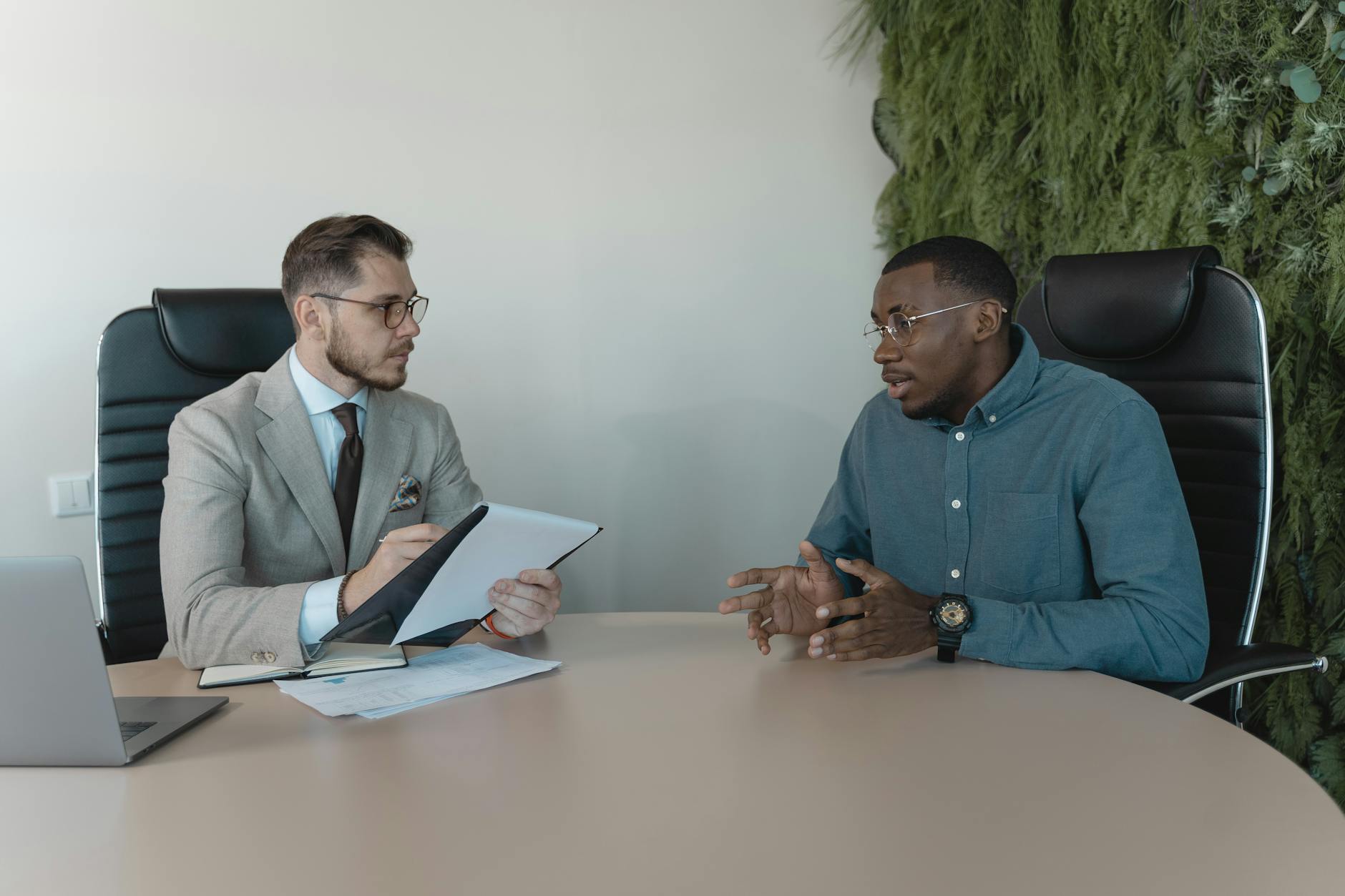 A hiring manager reviewing candidate profiles on a laptop during a technical screening session