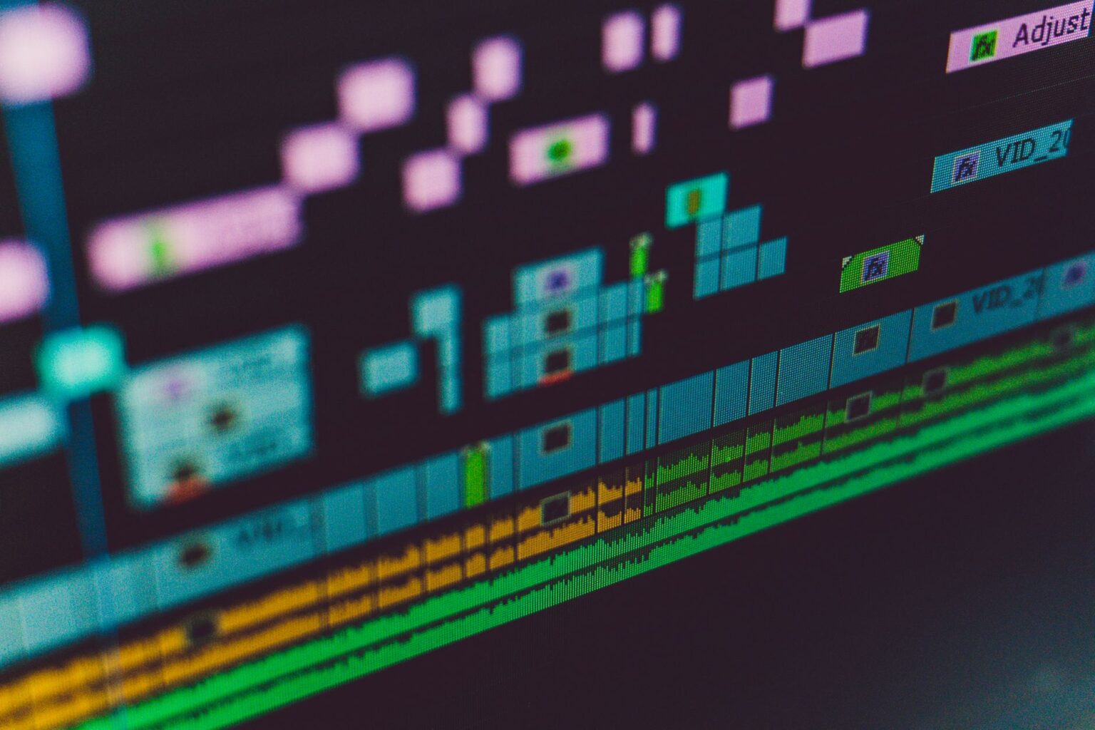 A person editing video on a laptop using professional software with a timeline visible on screen