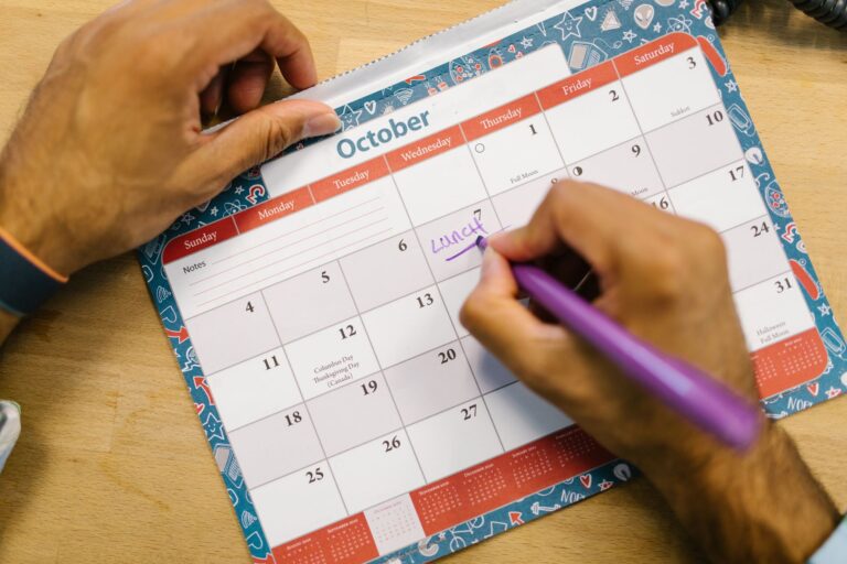 Notion’s Acquisition of Cron Is Finally Paying Off A desk with an open planner and laptop showing a digital calendar interface