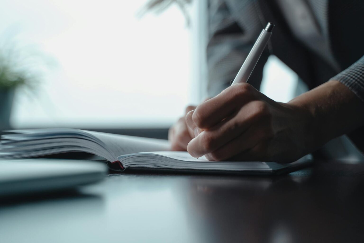 Legal associate at desk surrounded by documents and computer screens doing research