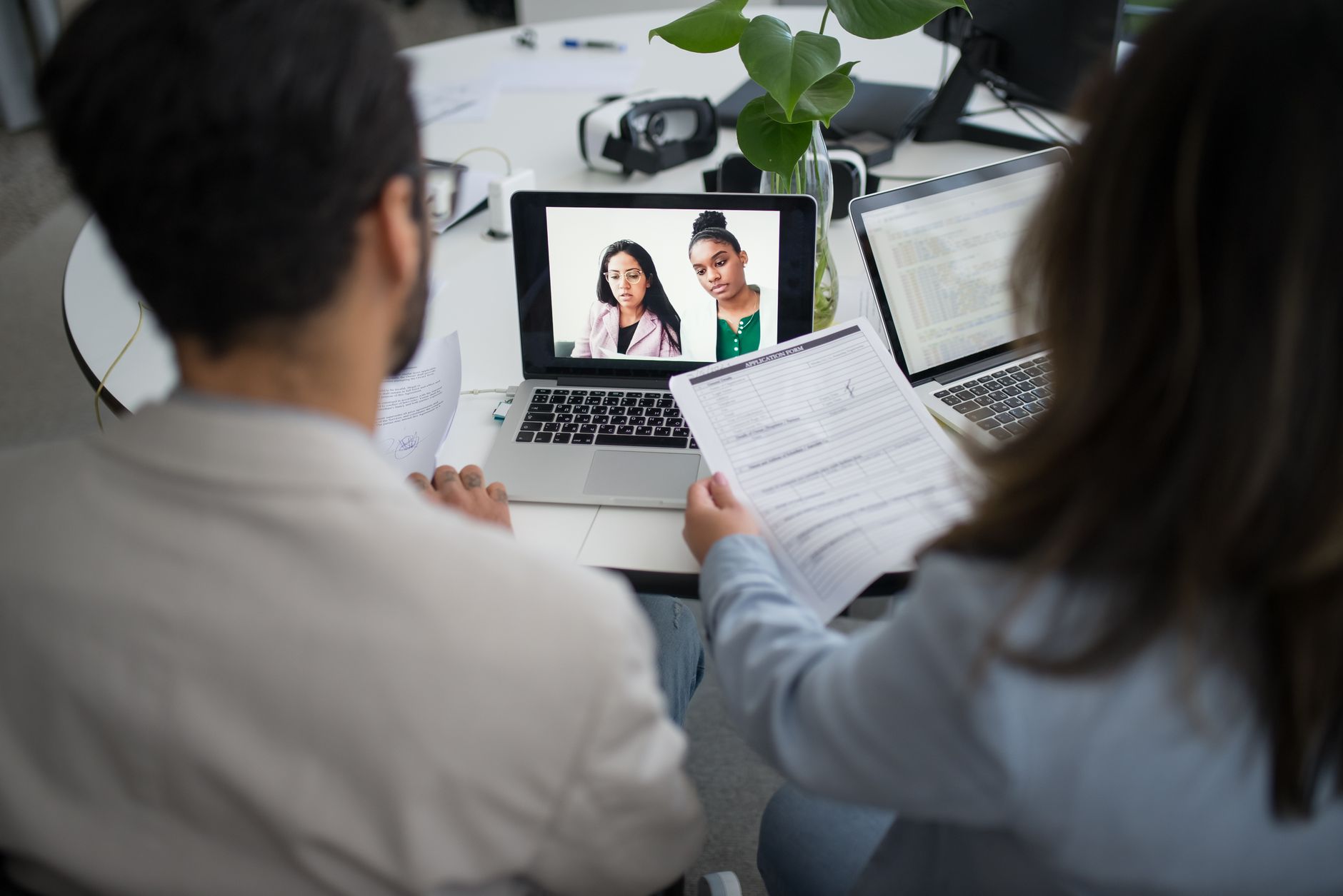 A person participating in a video job interview on a computer screen in a home office setting
