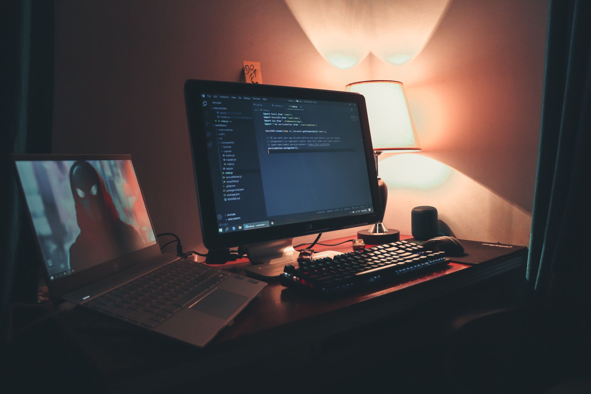 A programmer working at a desk with multiple monitors showing code