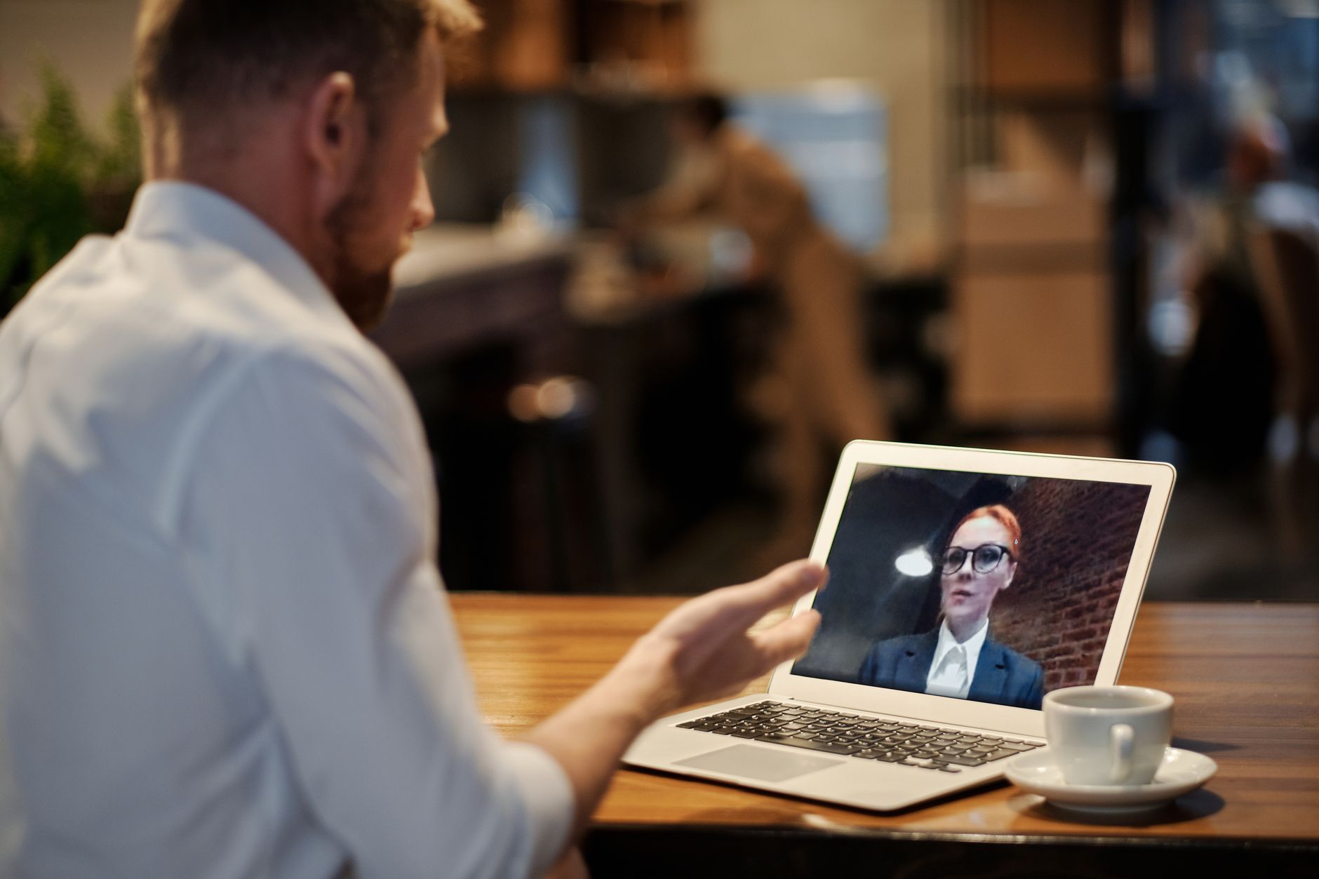 Professional on a video conference call at a desk with a computer screen