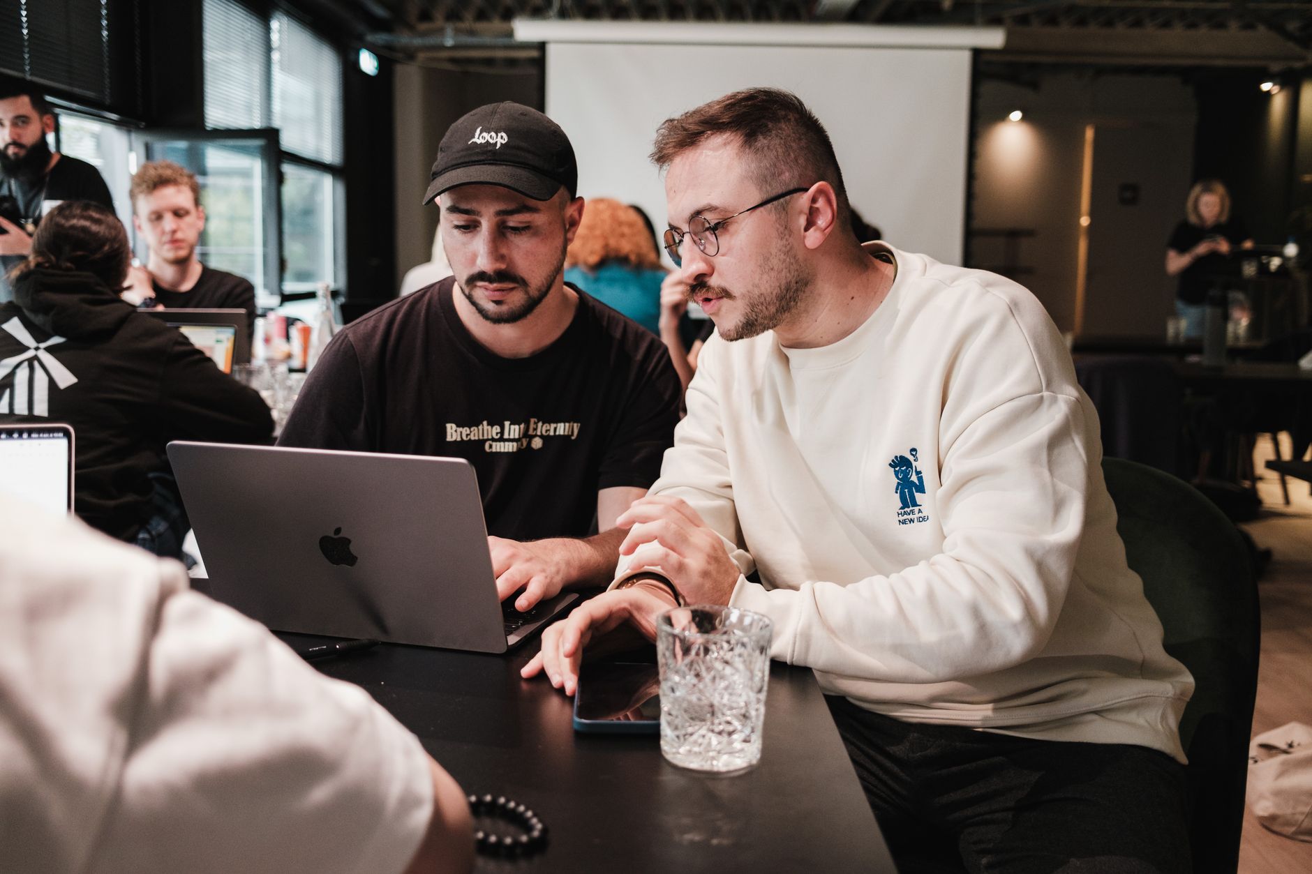 Small team collaborating around a laptop in a startup office setting