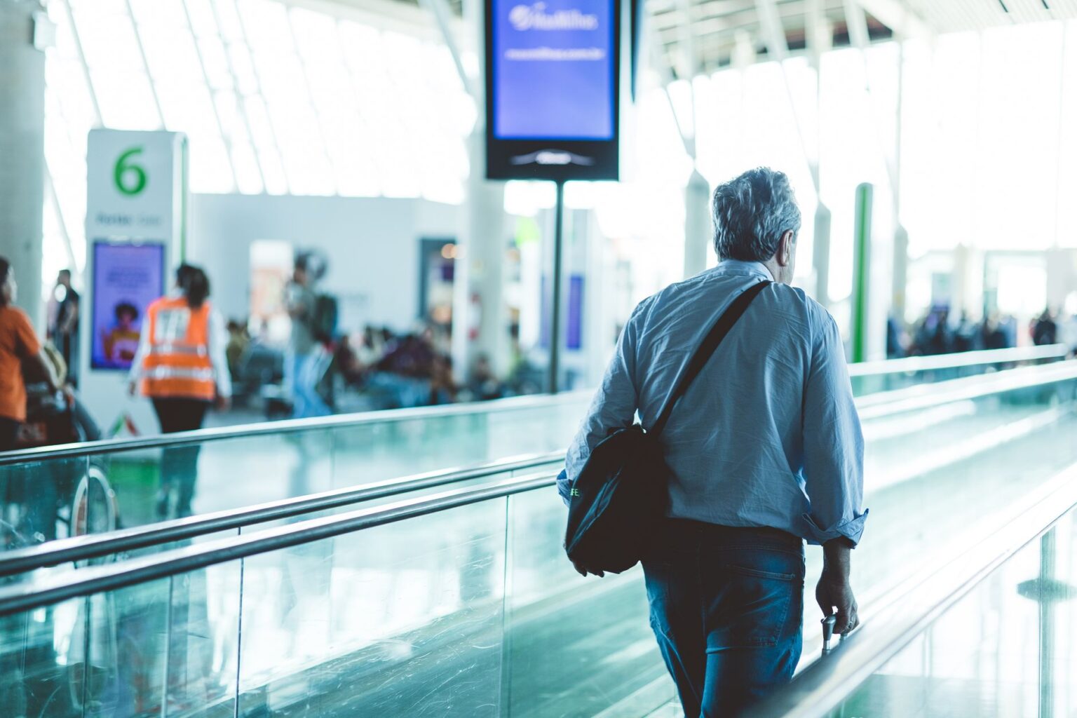 Navan’s Corporate Travel Push Is Squeezing Concur’s Enterprise Base Business traveler at airport terminal checking phone during corporate trip