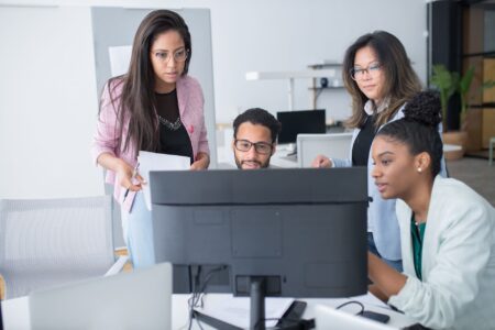Enterprise team collaborating around screens in a modern office environment