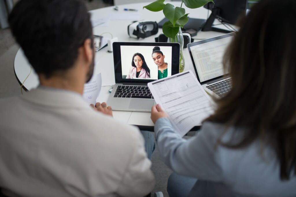 A person participating in a video interview on a laptop, representing AI-assisted hiring platforms