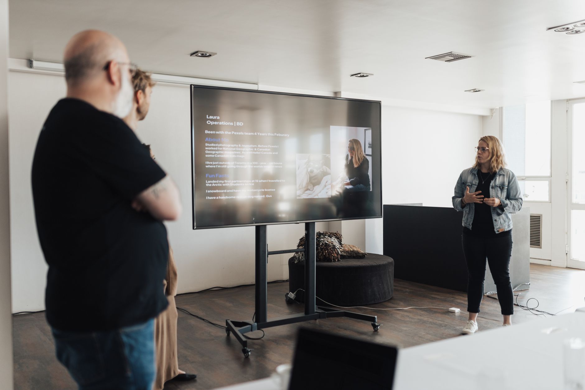 Colleagues collaborating around a screen displaying organized information and documents