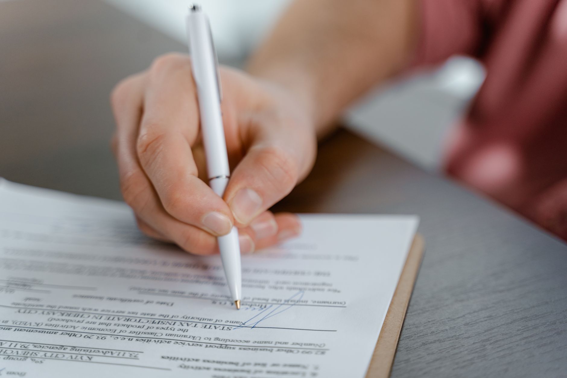 Two professionals reviewing and signing an enterprise software agreement at a desk