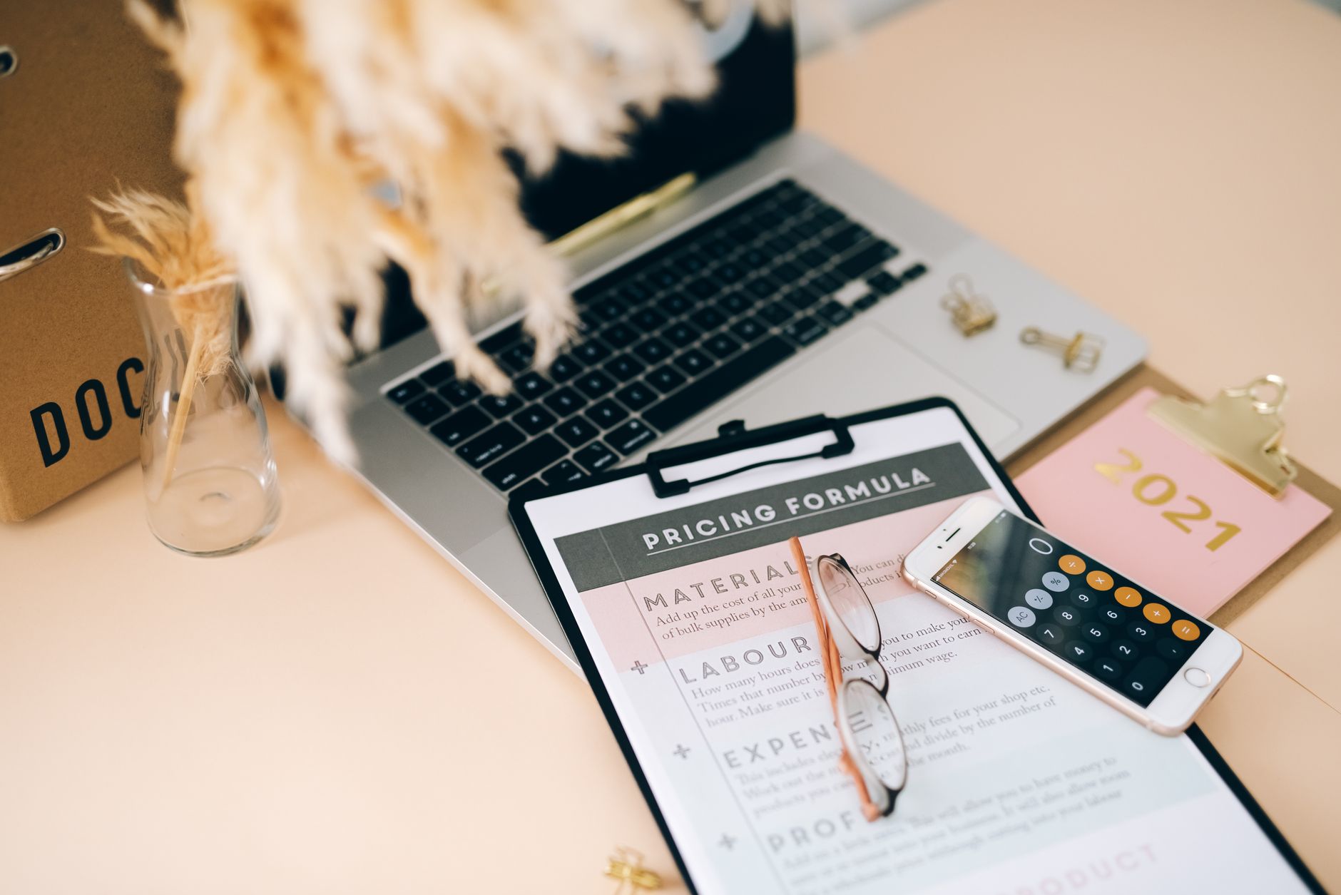 Business professional reviewing financial documents and pricing charts at a desk