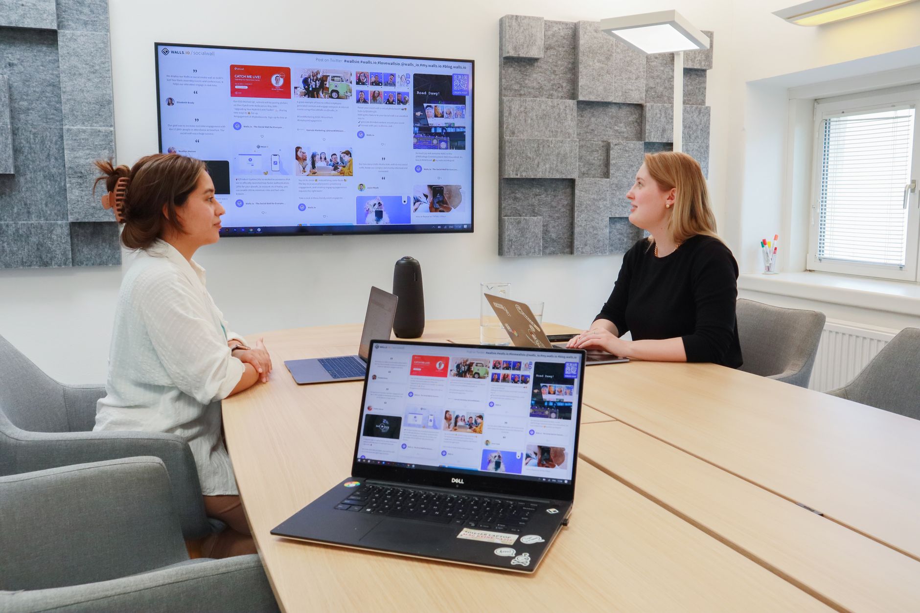 A modern office workspace with multiple monitors showing software interfaces used for enterprise operations