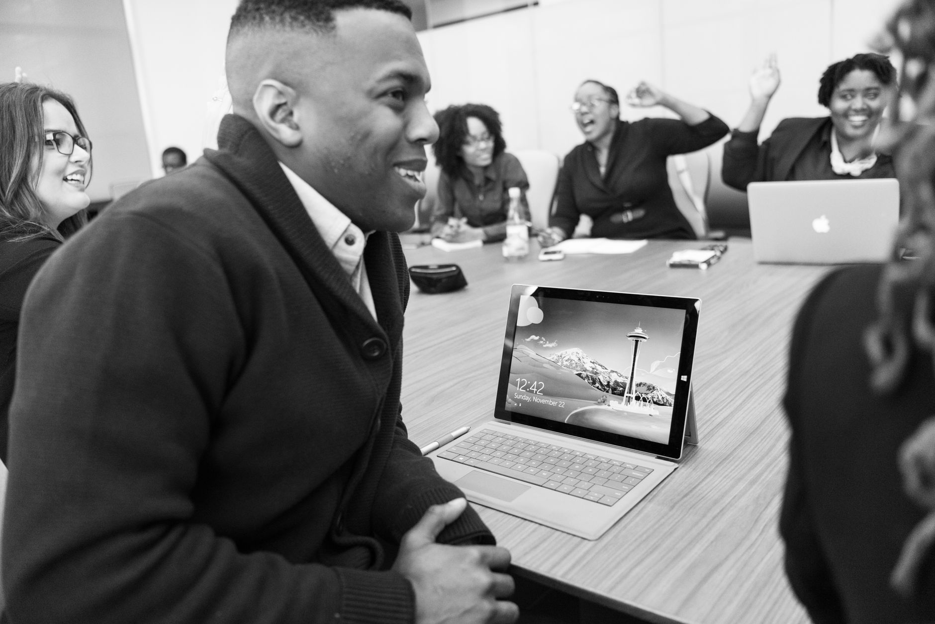 Tech professionals in a modern office discussing a project on a laptop
