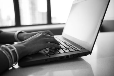 A person typing on a laptop, representing an AI-assisted writing workflow