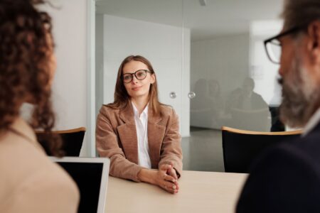 A hiring manager reviewing candidate profiles on a laptop during a recruitment session