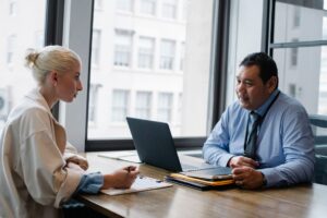 Ashby’s Recruiting Platform Is Quietly Cornering Greenhouse’s Mid-Market Base Two professionals conducting a job interview across a desk in a modern office