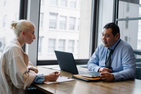 Ashby’s Recruiting Platform Is Quietly Cornering Greenhouse’s Mid-Market Base Two professionals conducting a job interview across a desk in a modern office