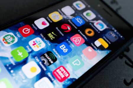 Capacitor’s Low-Code Mobile Layer Is Squeezing Expo’s React Native Base Developer working on a mobile application on a laptop and smartphone