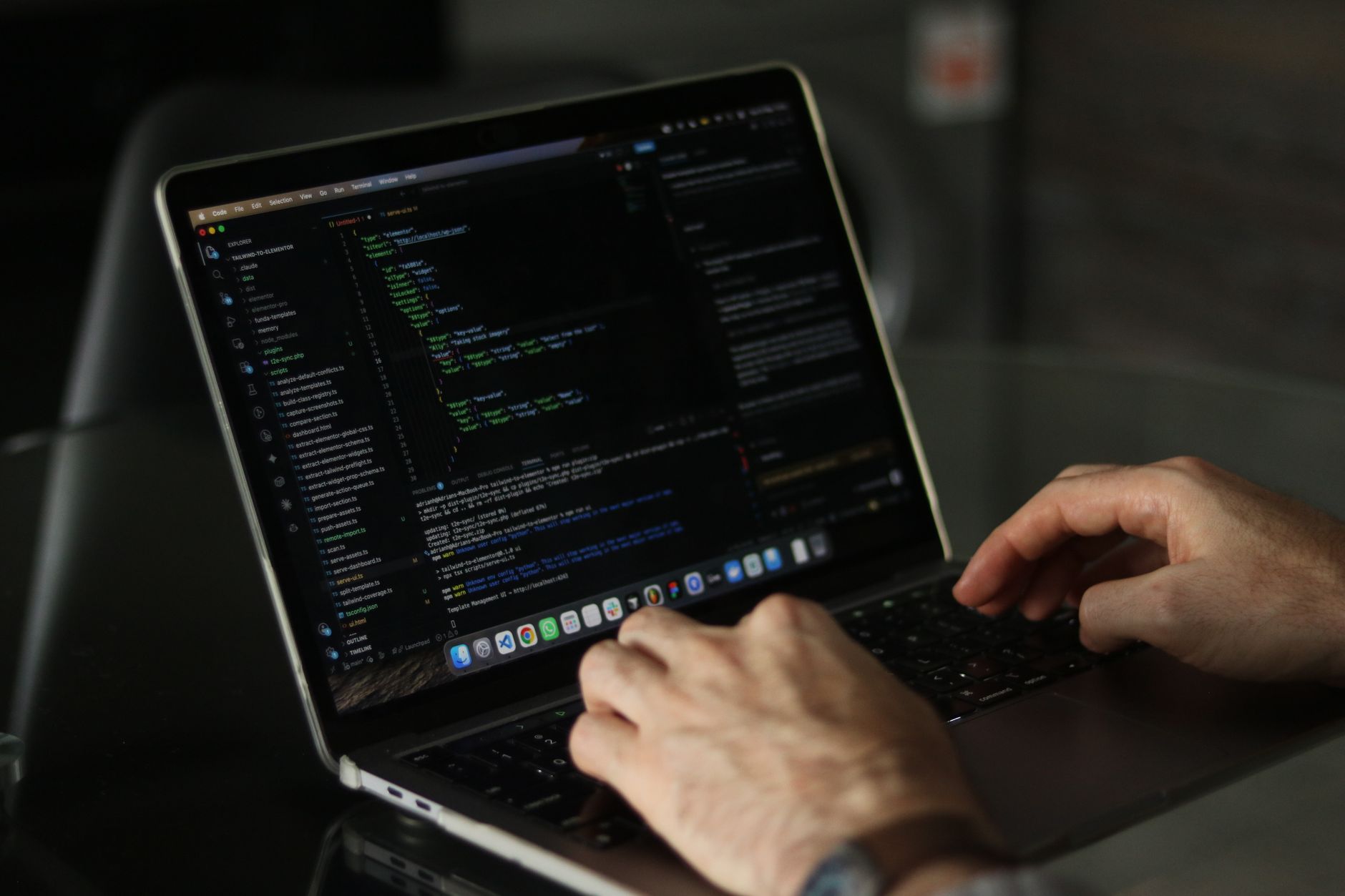 Developer working on a laptop with code editor open on screen