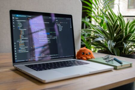 Developer working at a dual-monitor coding workstation with dark IDE visible on screen