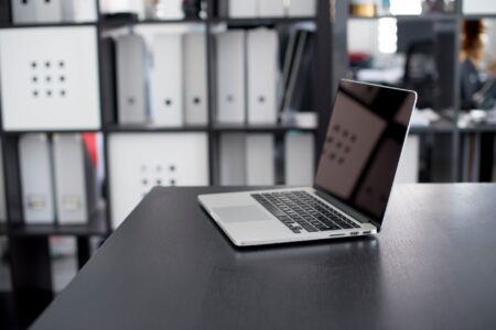 Person working on a laptop with a structured database interface on screen
