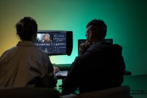 A professional desk setup with screens displaying video editing software for async communication