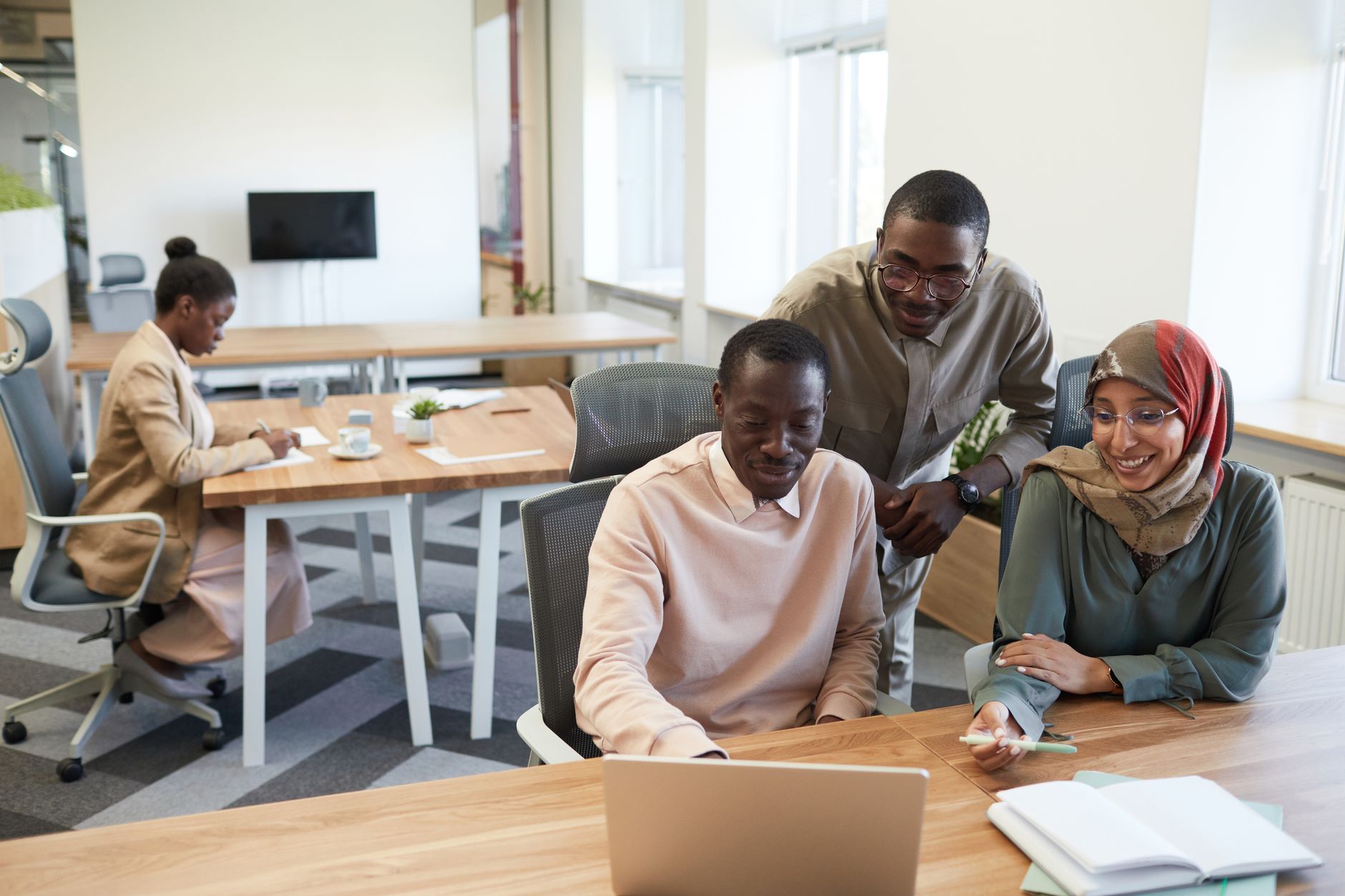 Small startup team collaborating at a modern open-plan office workspace