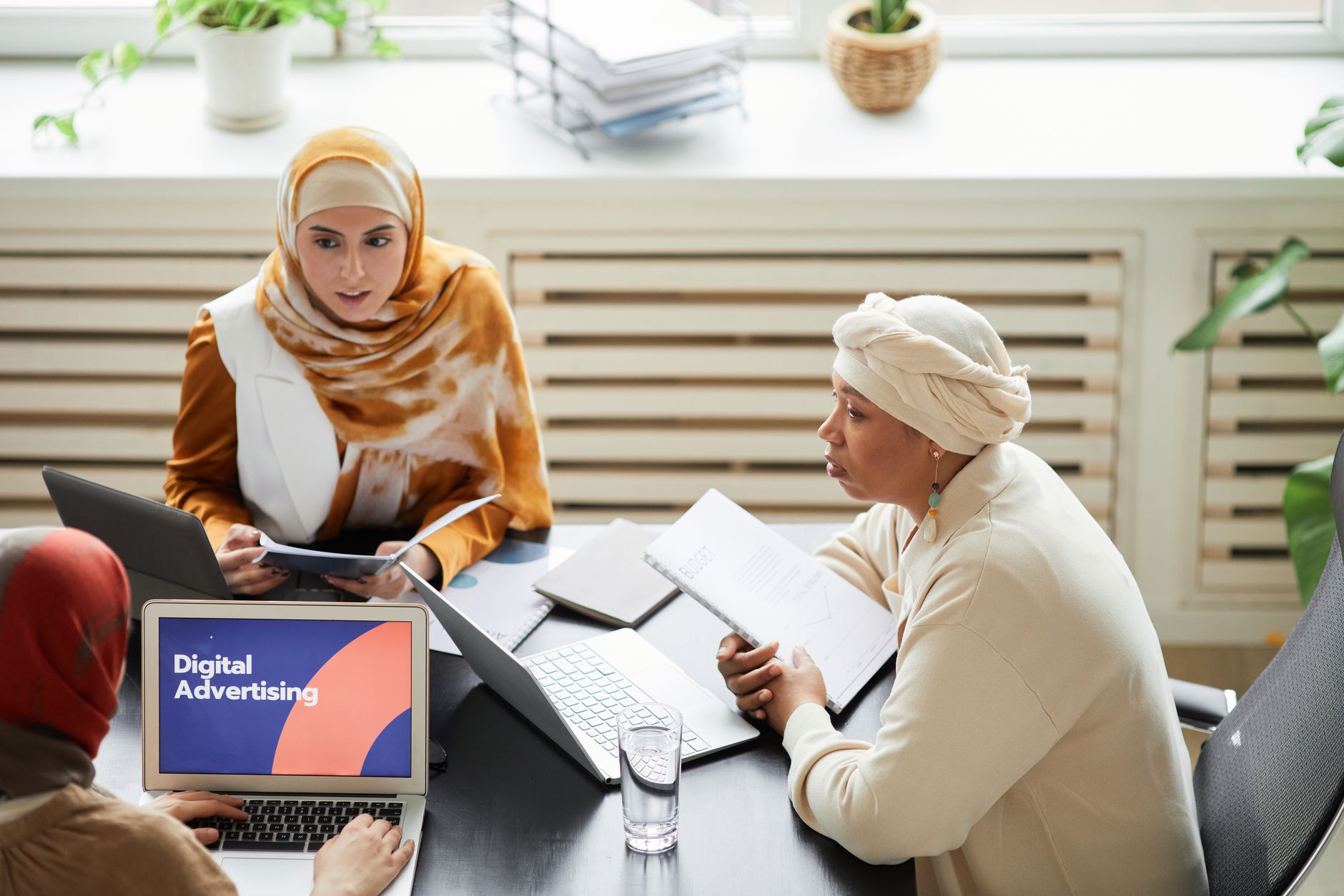 Marketing professionals reviewing digital advertising campaign data on monitors