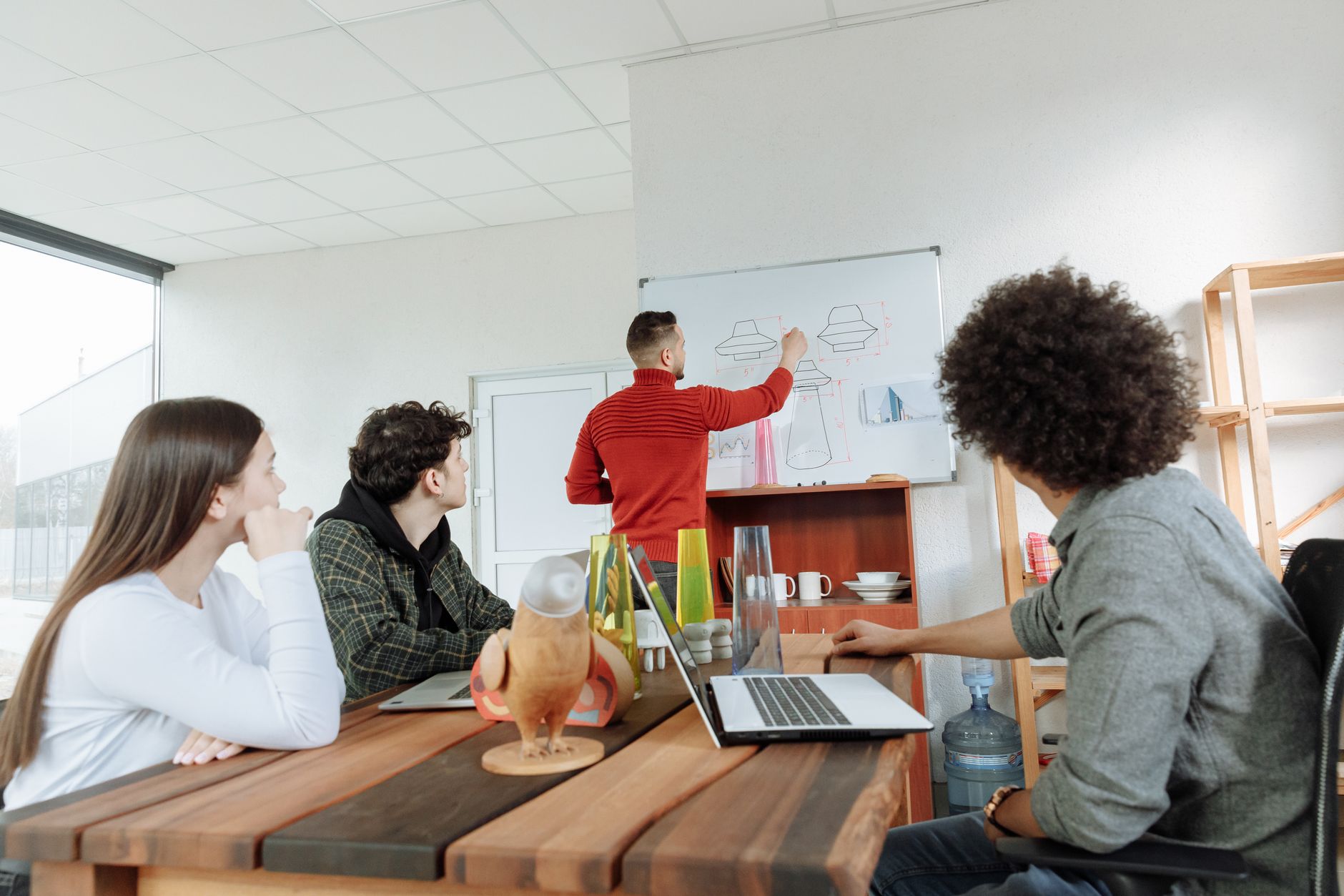 Small startup team gathered around a screen reviewing a slide presentation
