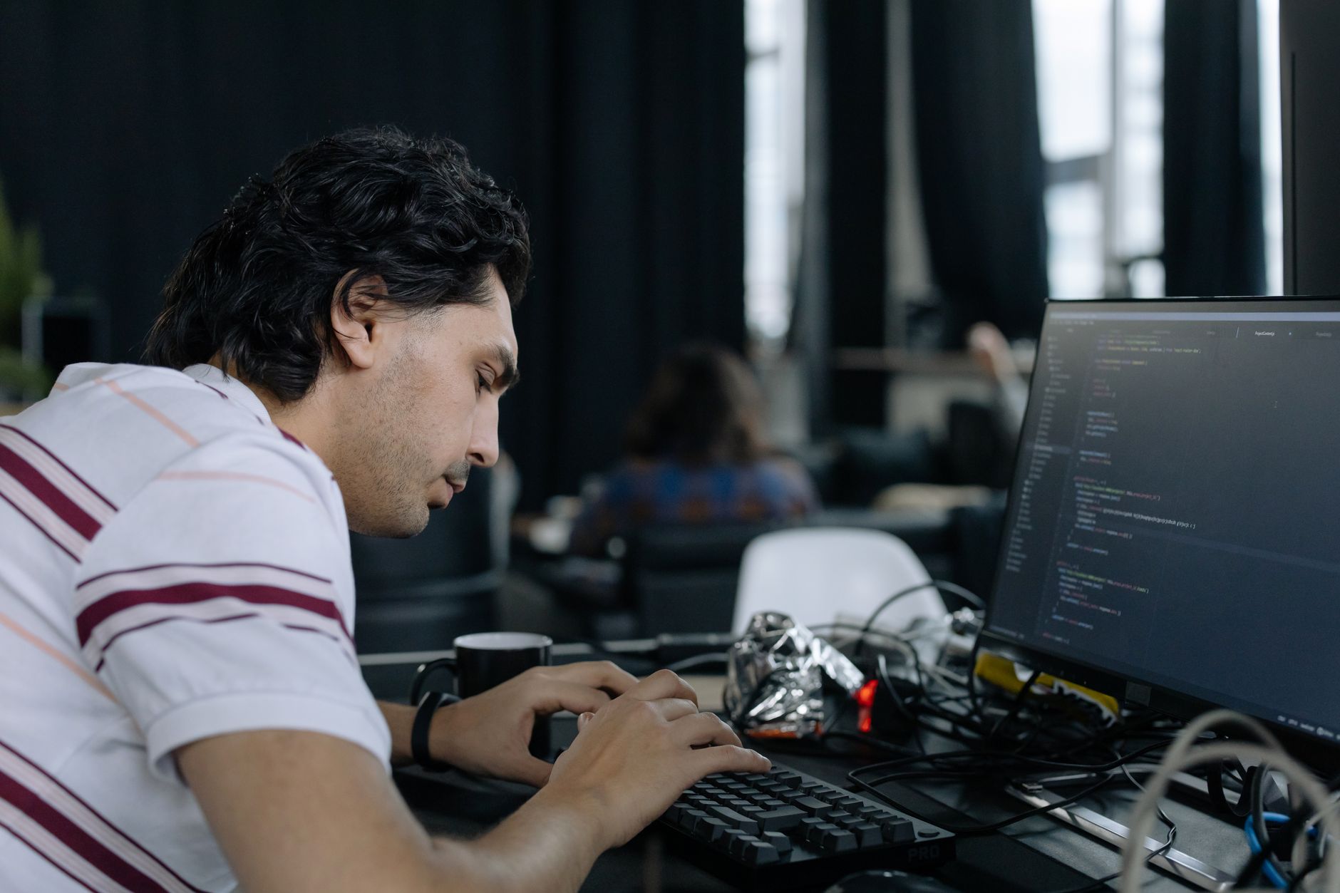 Software engineer working at a computer screen with code visible