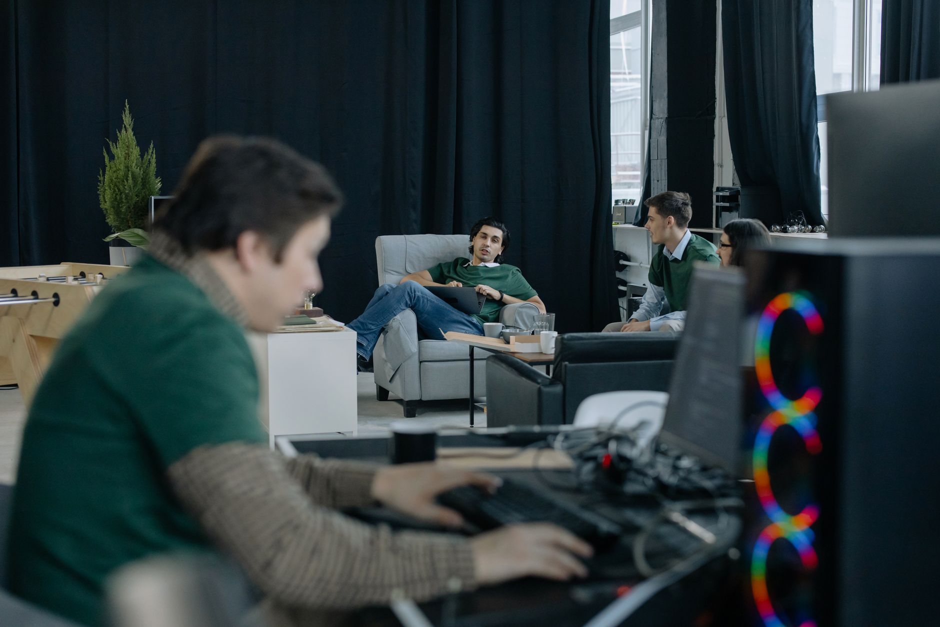 Open-plan startup office with developers working at standing desks