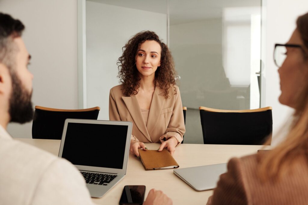 Ashby’s Recruiting Platform Is Quietly Cornering Greenhouse’s Mid-Market Base Two people in a professional office setting conducting a job interview across a desk